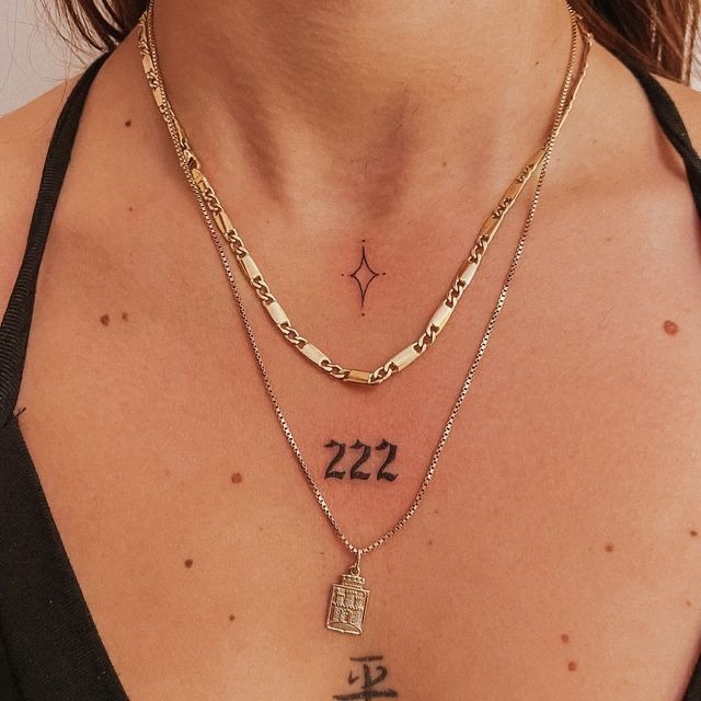 Collarbone Spark with 222, a tattoo design rendered in delicate fine-line for the neck.