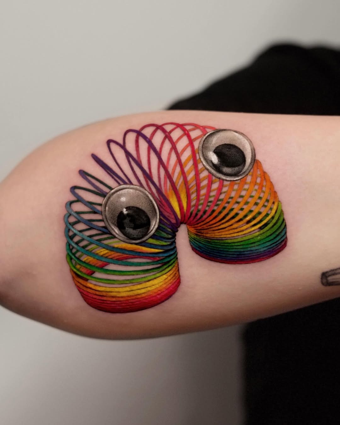 Playful 3D slinky tattoo with googly eyes Tattoo Design