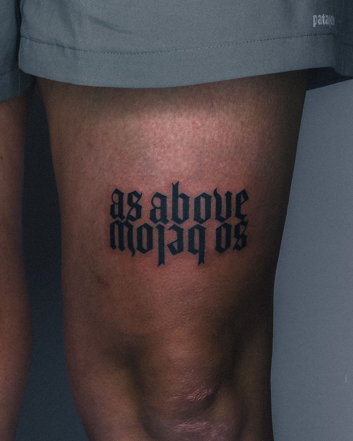 Gothic Quote Above the Knee Tattoo Design