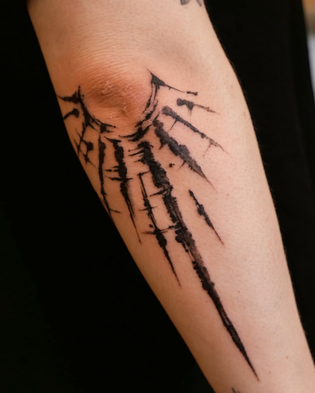 This abstract tattoo features striking sun rays extending from a central point, creating an energetic vibe.