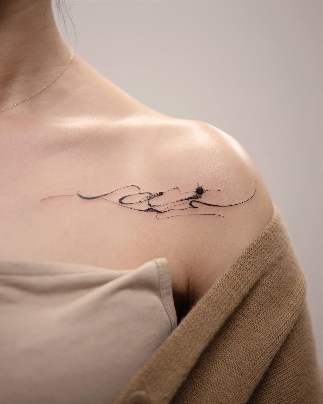 This abstract tattoo features delicate, flowing lines that create an elegant composition on the shoulder.