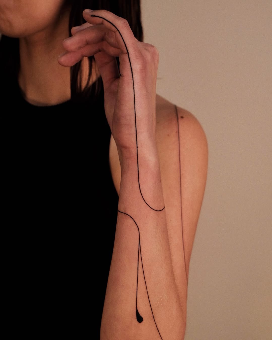 This tattoo features a striking minimalist design that elegantly flows along the arm.