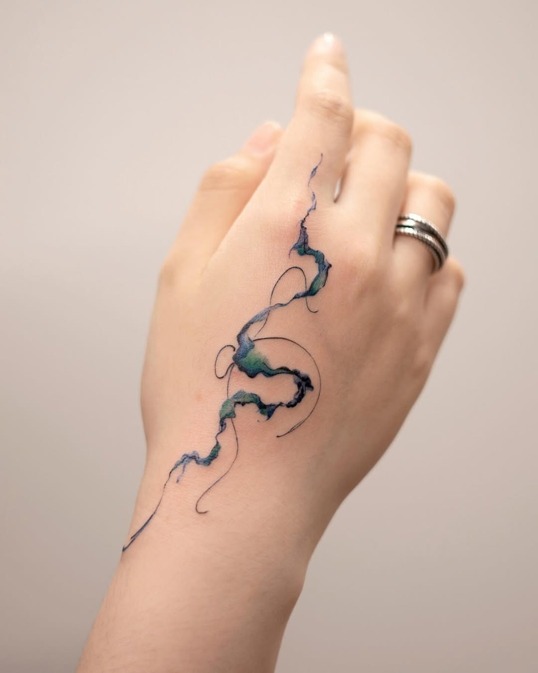 This abstract tattoo features, flowing colors that mimic natural forms, creating a captivating visual effect.