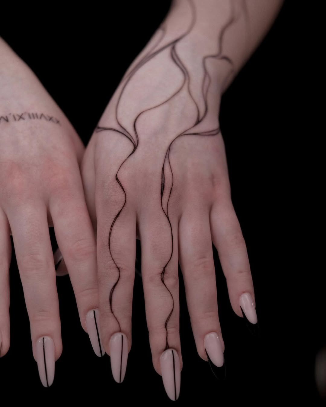 This abstract tattoo features smooth, flowing lines that elegantly wrap around the hands.