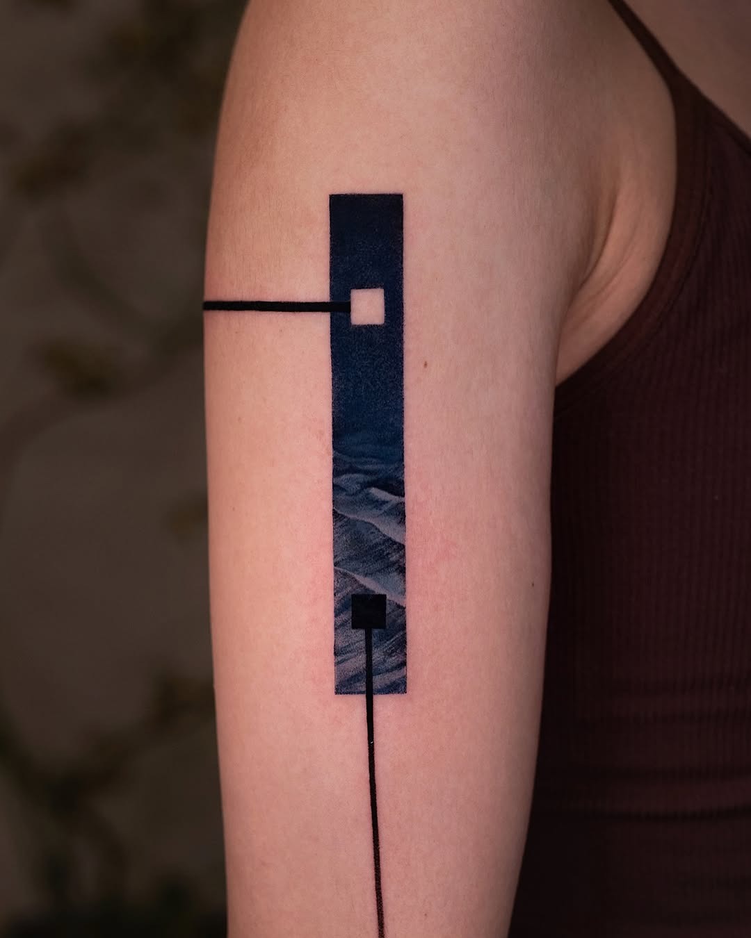 This tattoo features a stunning geometric design that integrates a landscape scene, blending the abstract with nature.