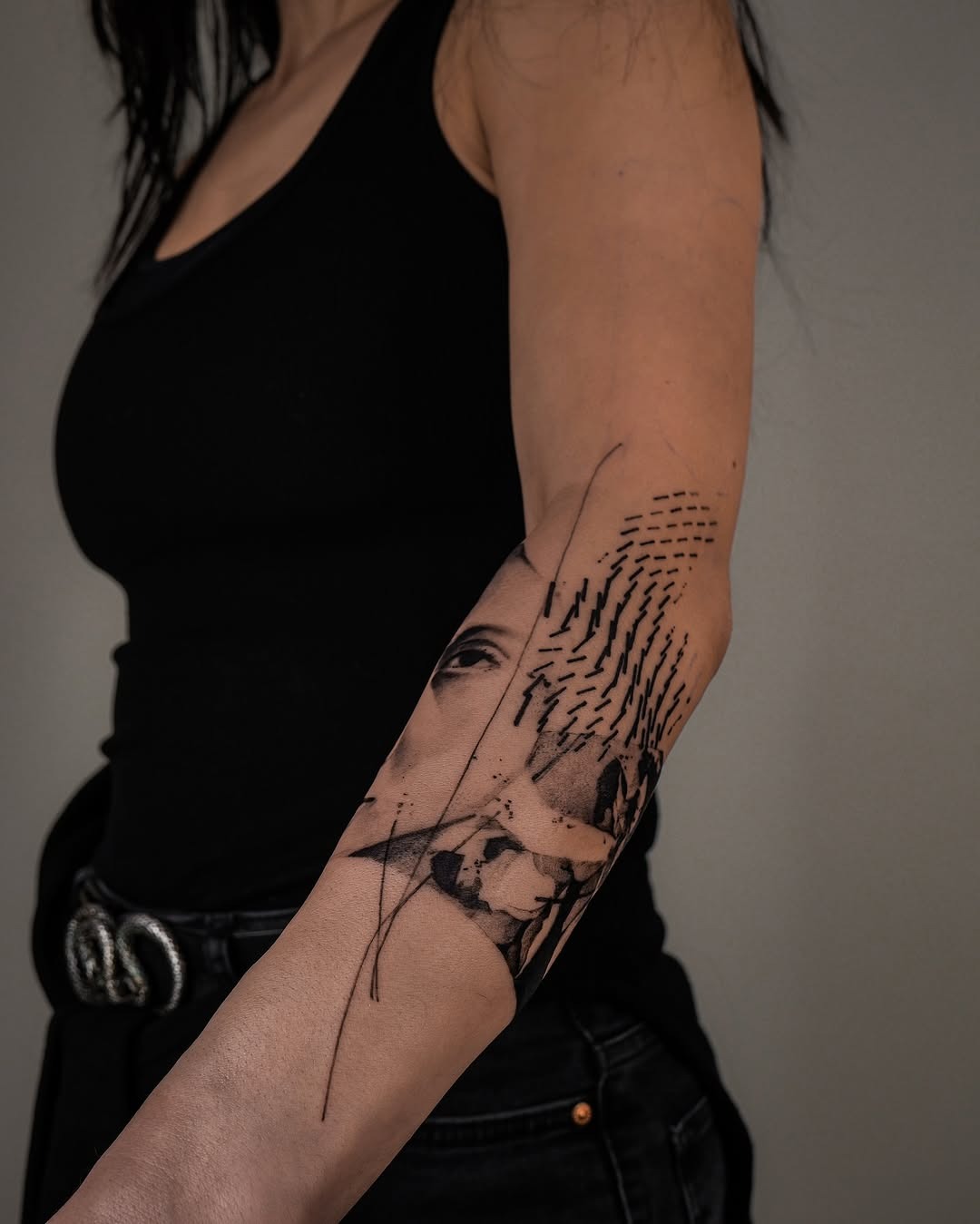 This abstract tattoo features a blend of artistic elements, showing a striking mix of lines and a face.