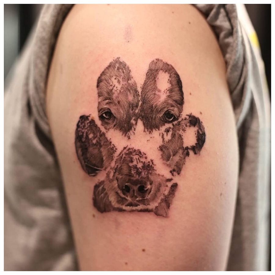 Unique paw print tattoo featuring dog faces Tattoo Design