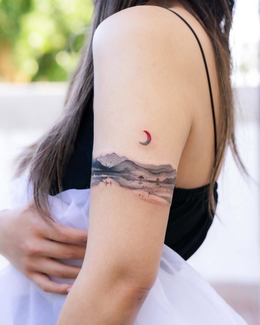 This tattoo showcases a beautiful blend of mountains and a crescent moon.