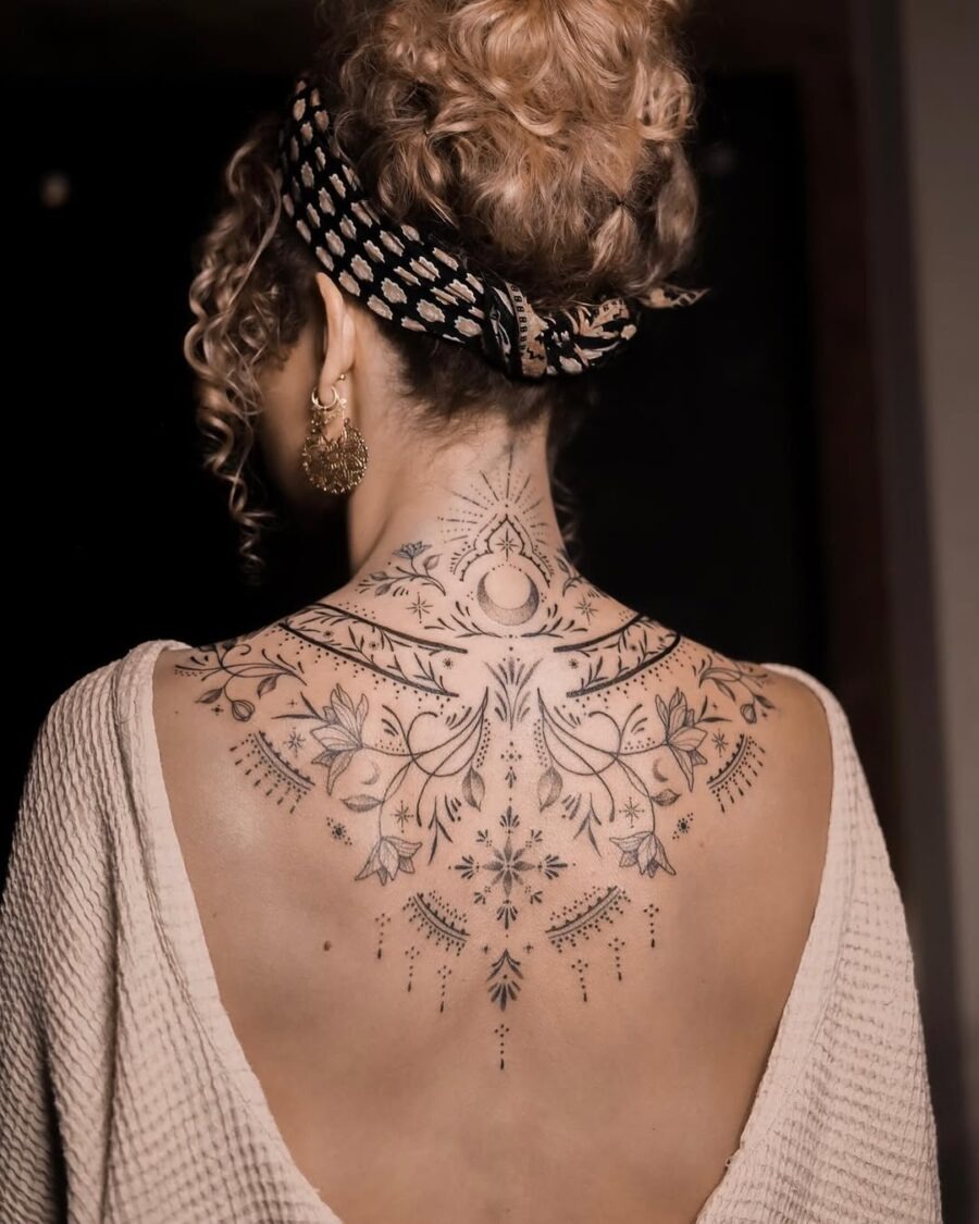 This stunning back tattoo features a delicate floral pattern that sprawls elegantly across the skin.