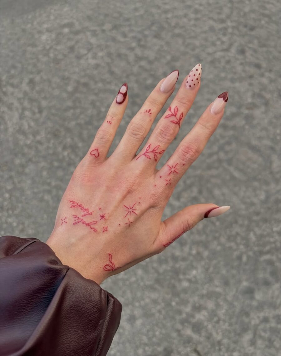 This collection features subtle red floral tattoos adorning the hand.