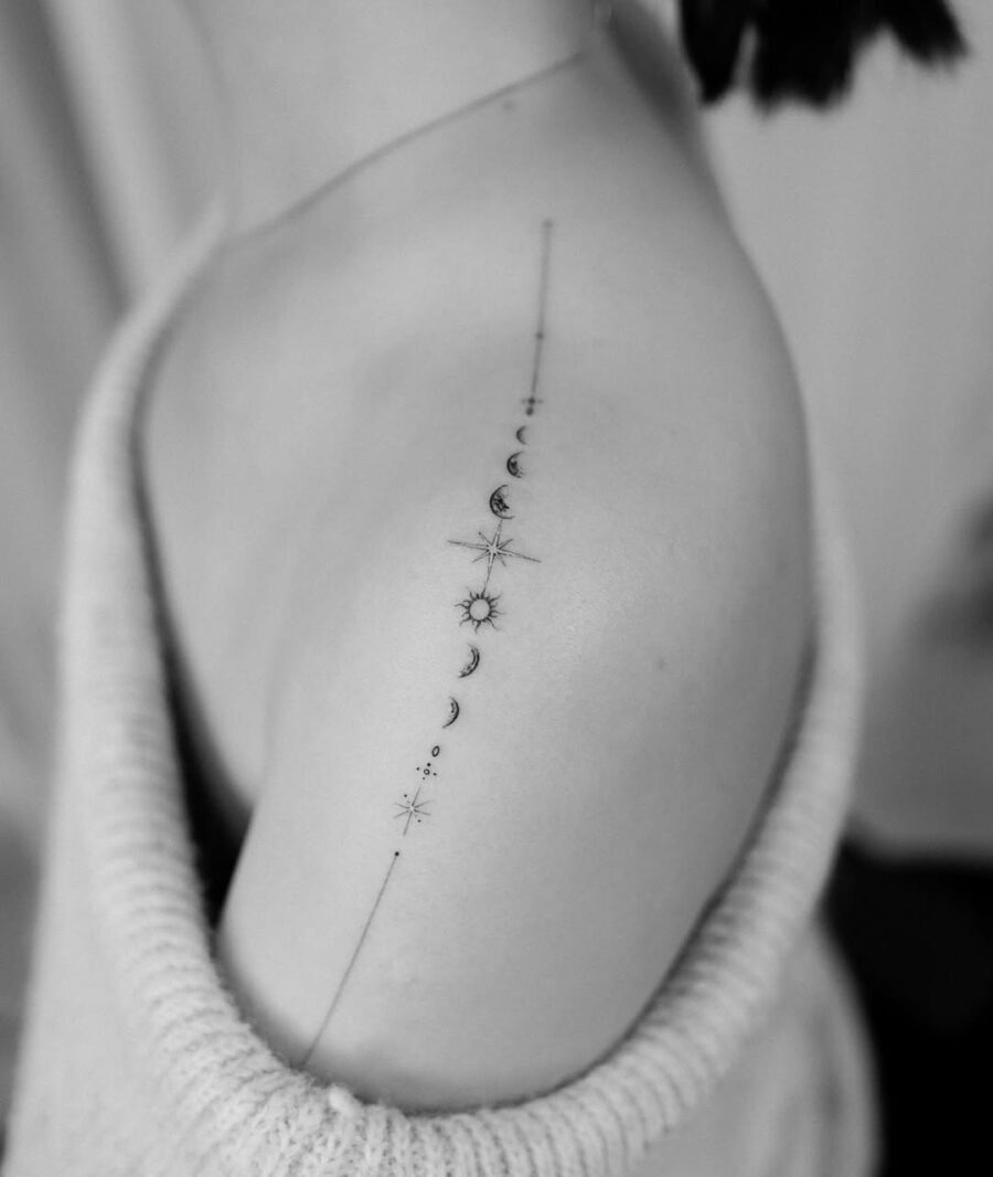 This aesthetic tattoo showcases a delicate alignment of celestial motifs along the shoulder.