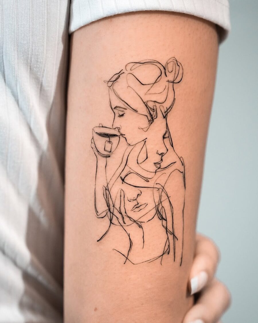 This tattoo features a delicate line art depiction of a woman intertwined with soft shapes.