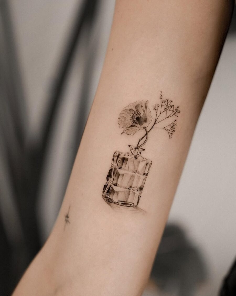 This tattoo features a beautifully detailed flower in a glass vase.