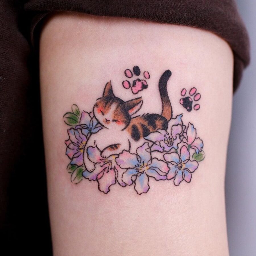This tattoo beautifully illustrates a serene cat nestled in flowers, exuding a cozy, whimsical vibe.