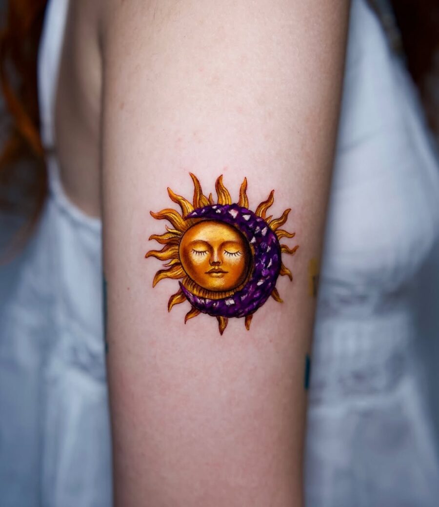 This stunning tattoo features a sun and moon motif with striking orange and purple hues.