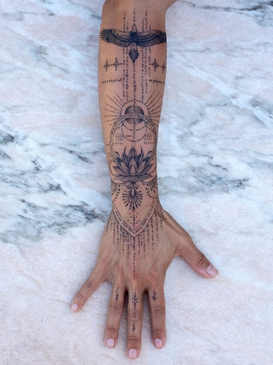 This stunning tattoo showcases a large lotus flower surrounded by intricate geometric patterns and celestial elements.