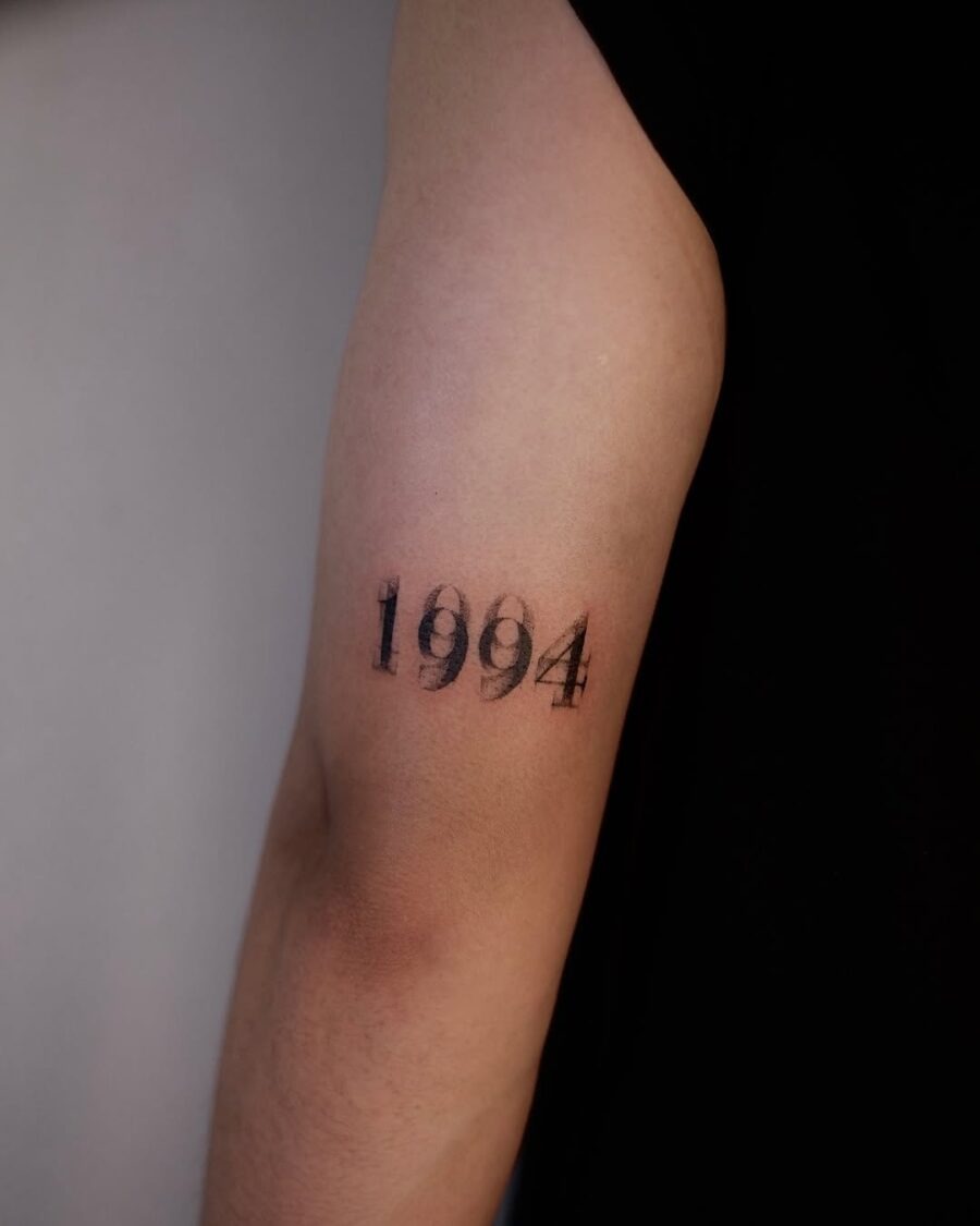 This tattoo beautifully displays the year 1994 in a minimalist black ink style.