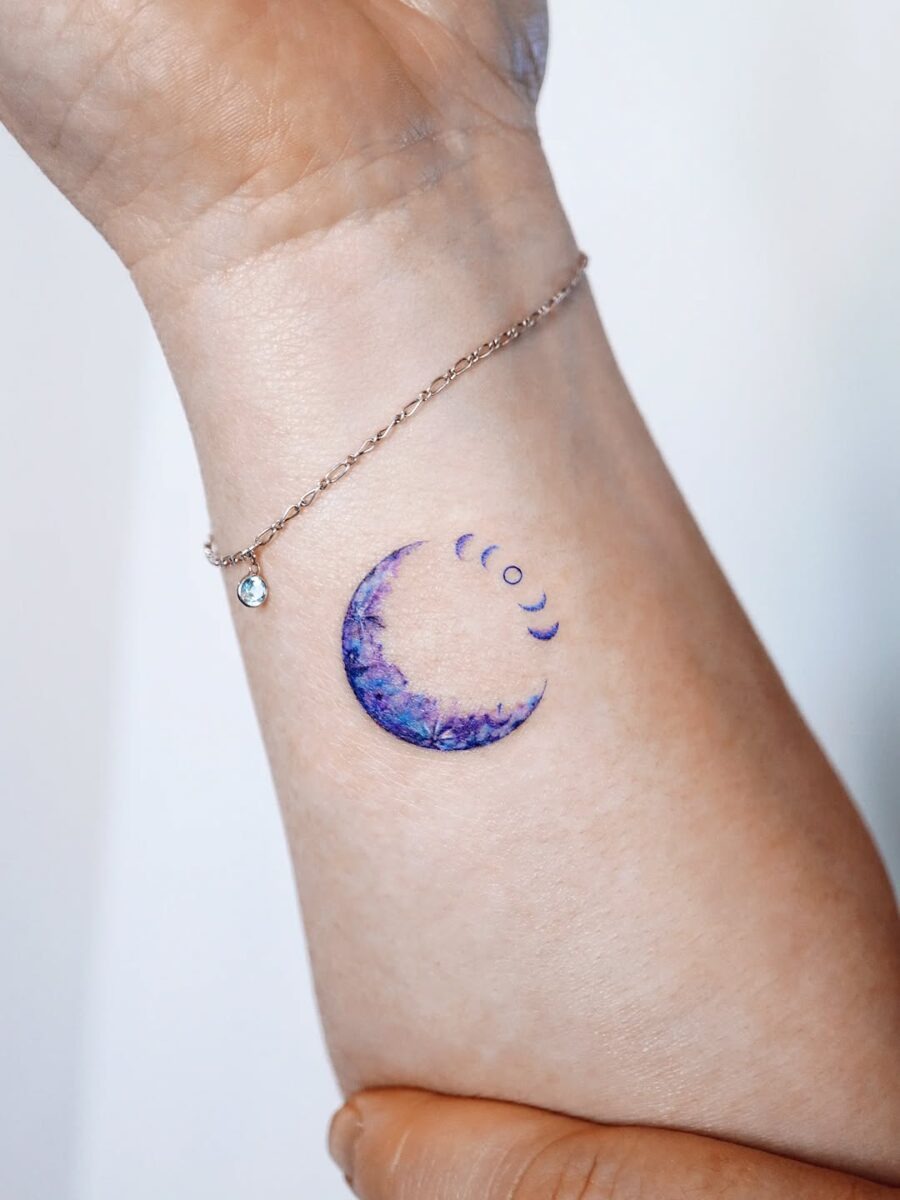 This tattoo features a beautifully designed crescent moon embellished with stunning purple hues.