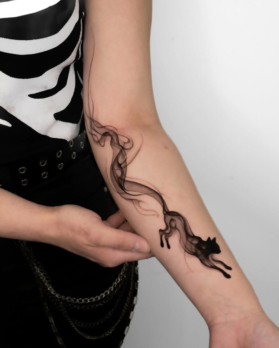 This tattoo features a sleek and fluid design of a cat, showing minimalist artistry.