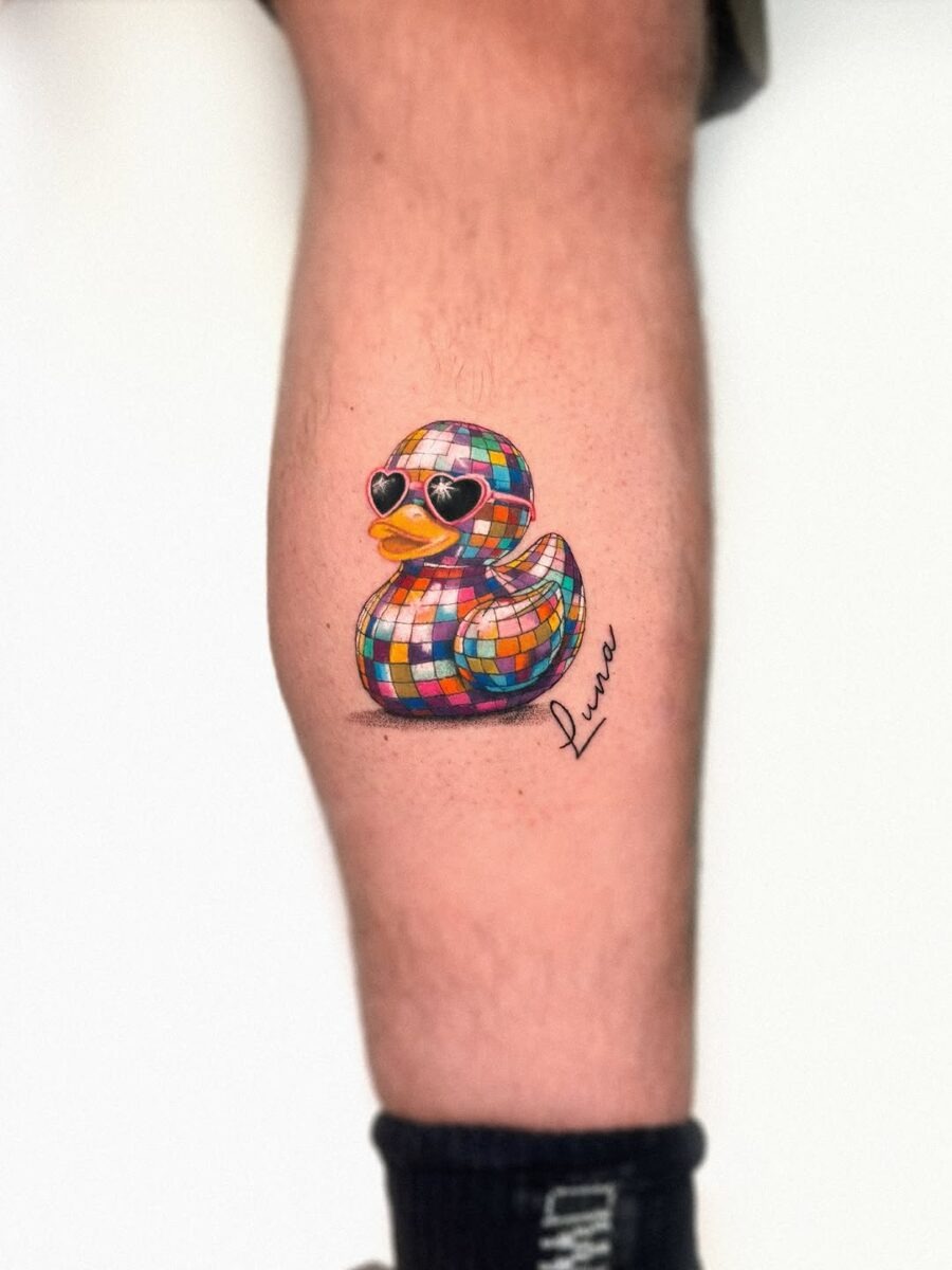 This colorful tattoo features a disco-themed duck wearing heart-shaped sunglasses.
