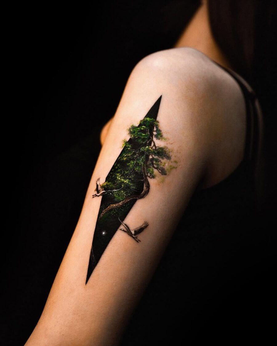 This tattoo features a stunning forest landscape, intricately designed to look like it's part of the skin.