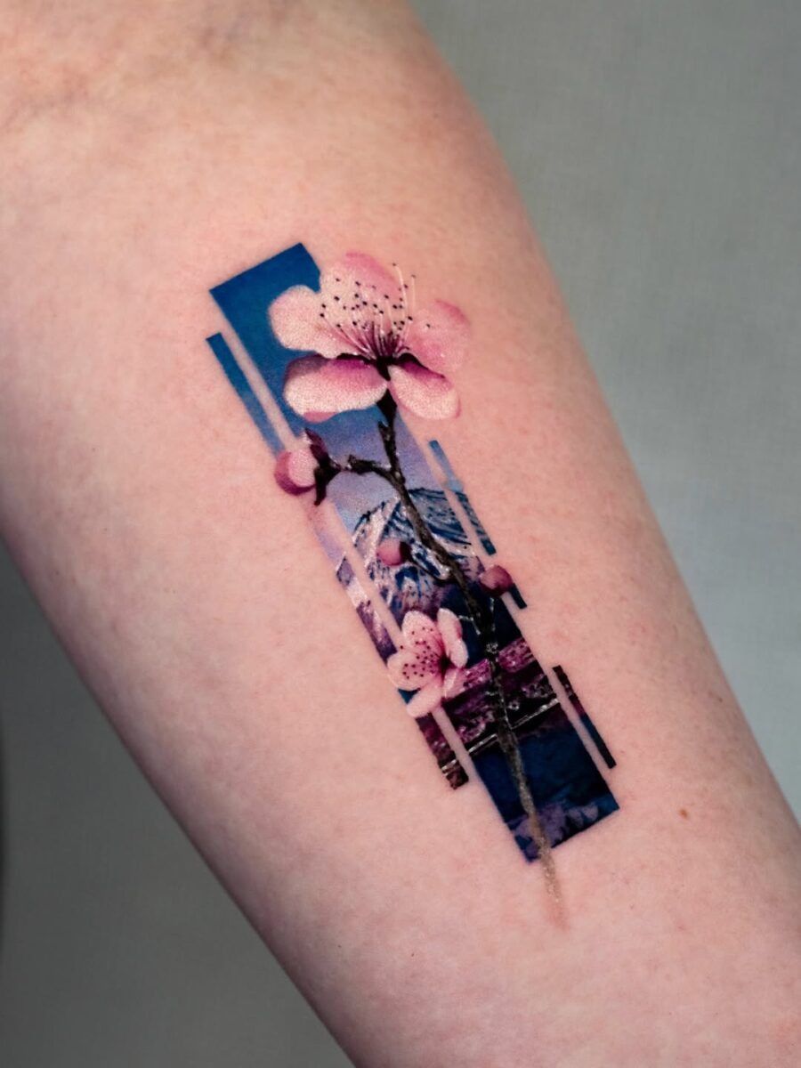 This tattoo features a delicate cherry blossom stem with soft pink petals, framed by abstract geometric lines.