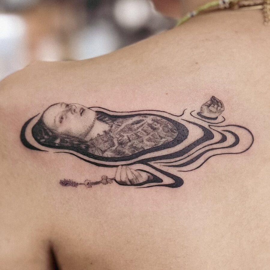 This tattoo features a stunning wavy silhouette design that gracefully wraps around the shoulder.