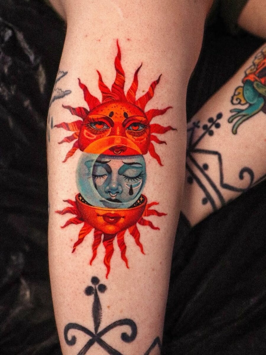 This tattoo showcases a sun and moon design, combining vivid colors and intricate details.