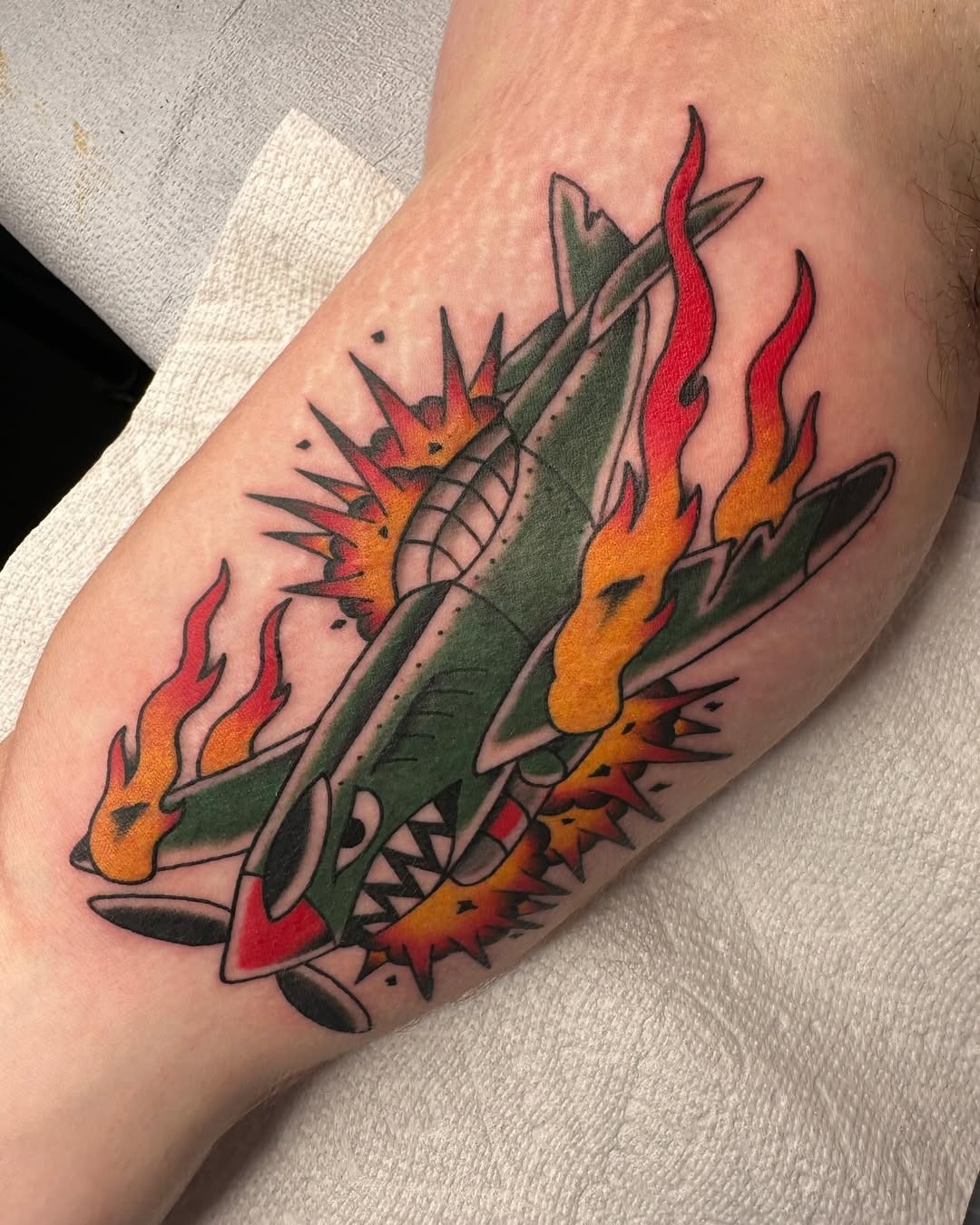 Dynamic airplane tattoo with explosive elements Tattoo Design