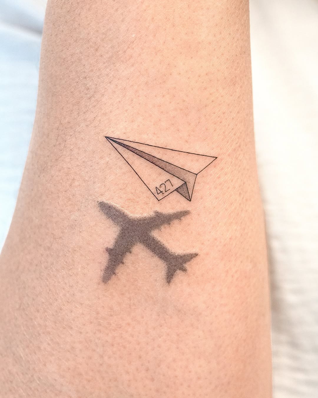Unique airplane tattoo with paper plane design Tattoo Design
