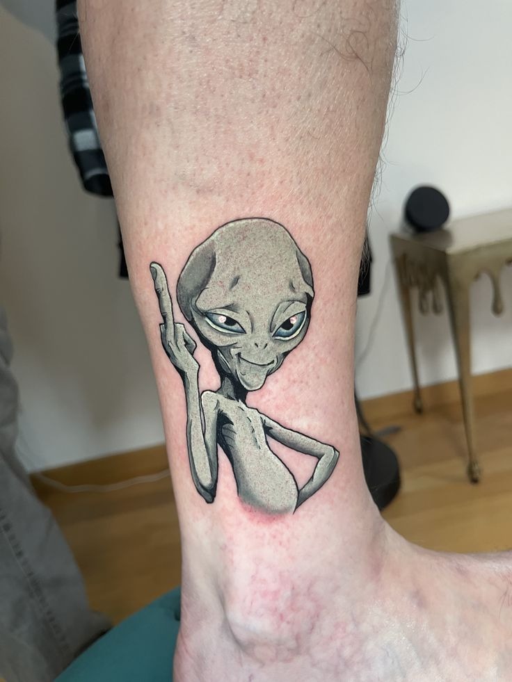 Cartoon Alien with Attitude Tattoo, a tattoo design rendered in clean detailed linework.