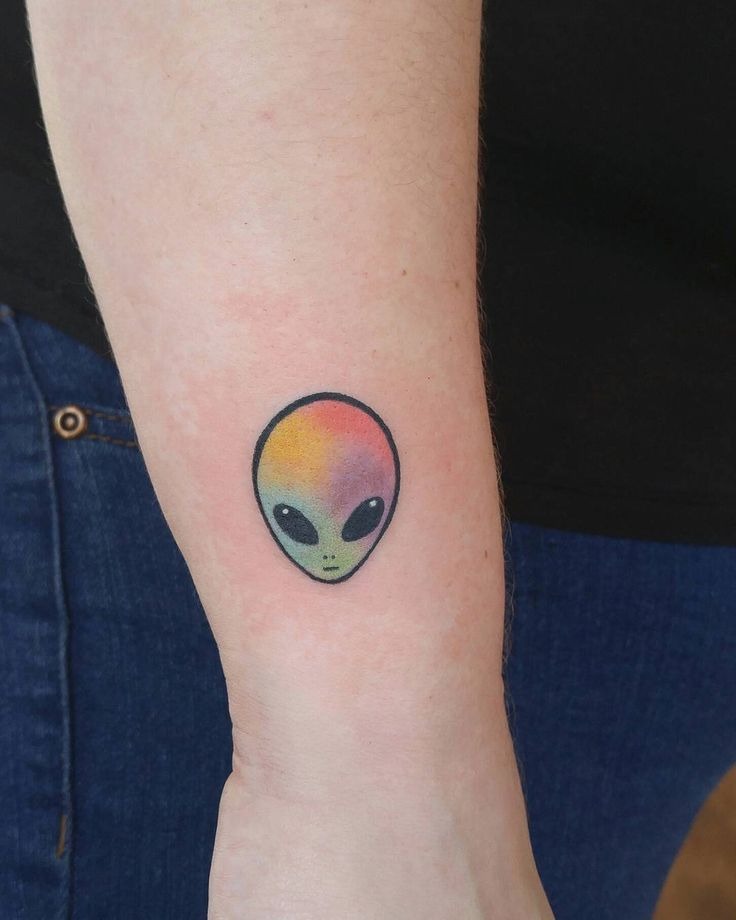 Mini Rainbow Alien Head Tattoo, a tattoo design rendered in minimalist fine-line.