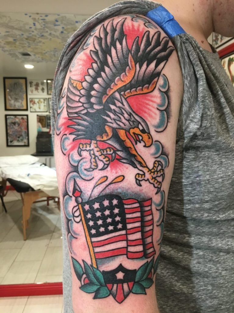 Dual arms adorned with symmetrical American traditional flash tattoos and roses