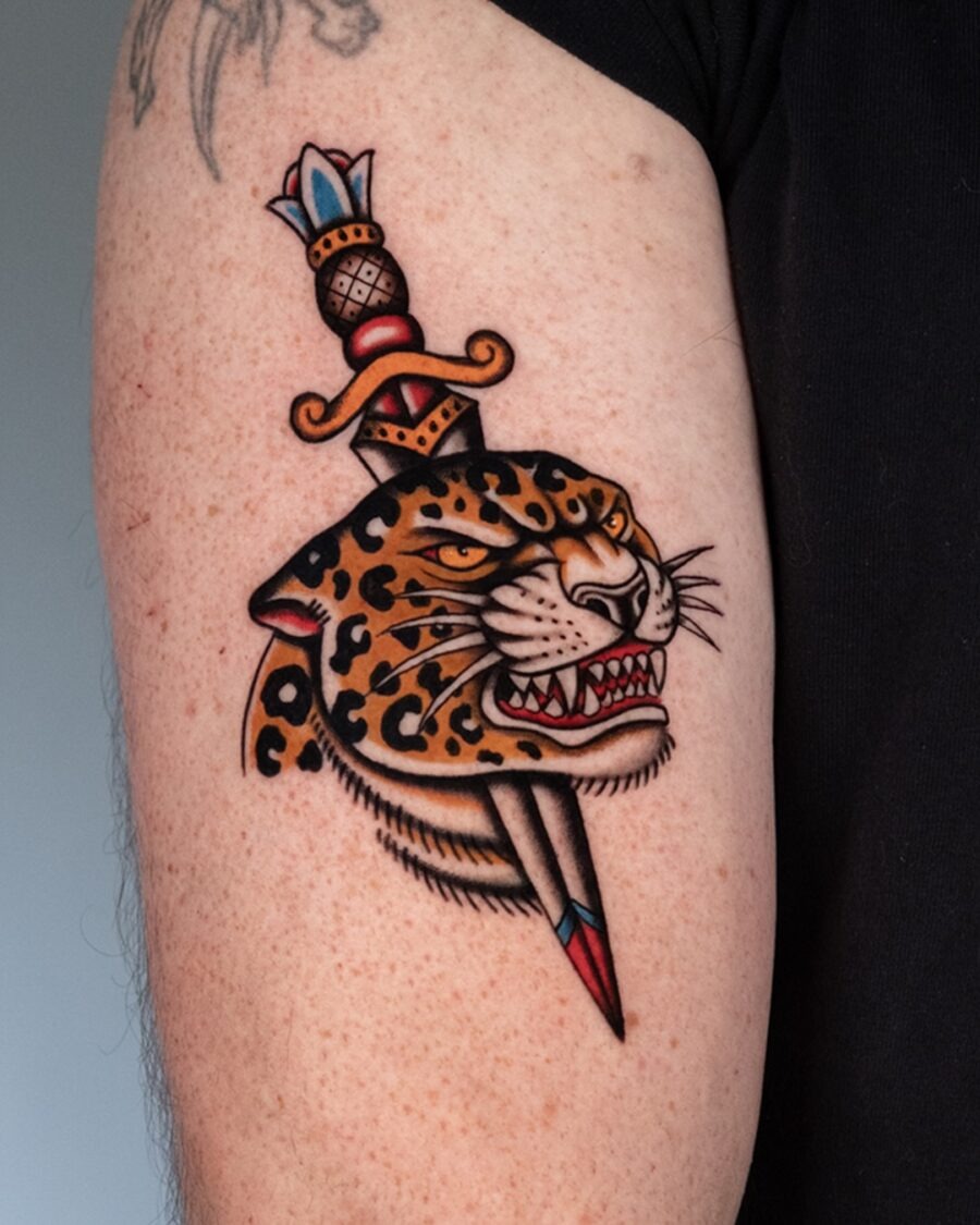 Elegant leopard tattoo with dagger detail Tattoo Design