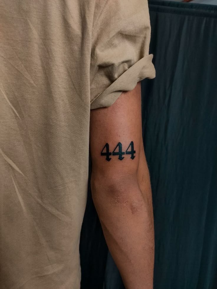 This clean and powerful 444 tattoo for men is designed in a thick, downward-pointing Gothic font, giving the ink an assertive presence on the upper tricep.