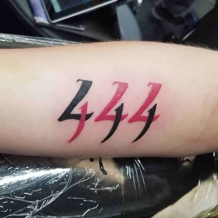 Talk about bold. This 444 tattoo features jagged lightning-style digits, each split down the middle into vivid red and bold black halves.