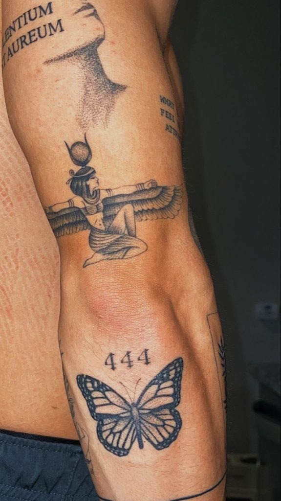 Small but meaningful, this 444 tattoo sits just above a butterfly design on the upper arm.