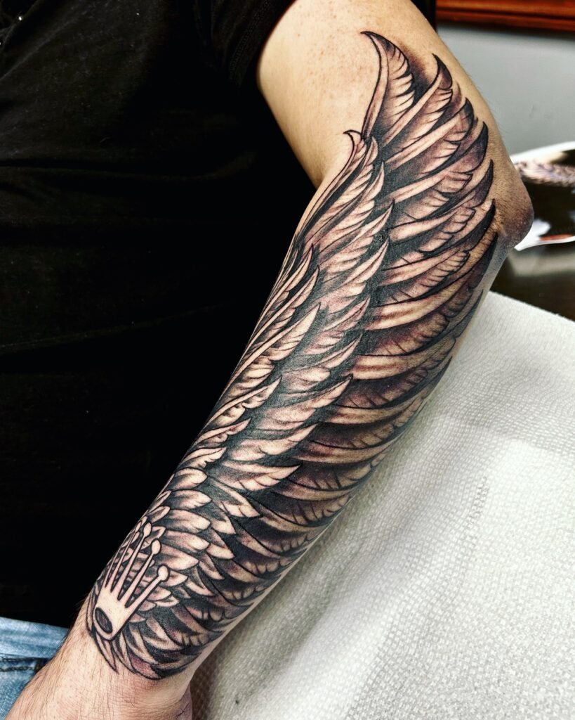 Realistic Angel Wing Forearm Tattoo with Roman Numerals Tattoo Design