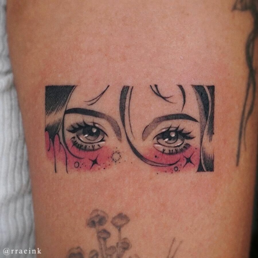 This tattoo features striking anime eyes with delicate shading and sparkles, creating a whimsical vibe.