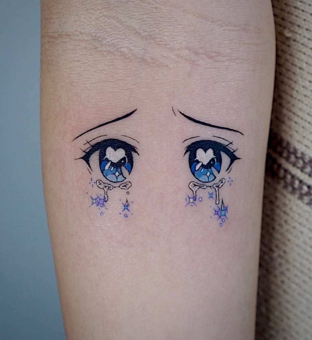 This tattoo features a pair of expressive anime eyes, capturing a sense of emotion and depth.