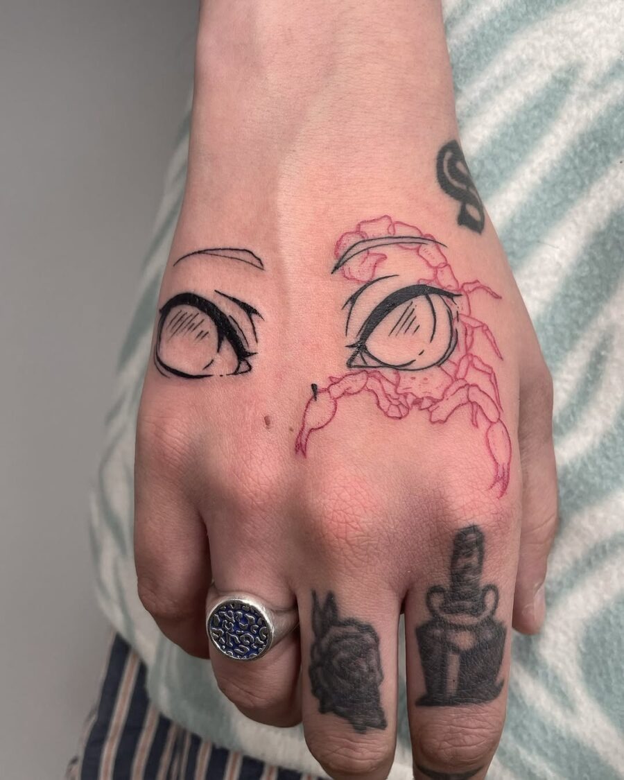 This tattoo features beautifully detailed anime eyes on a hand.