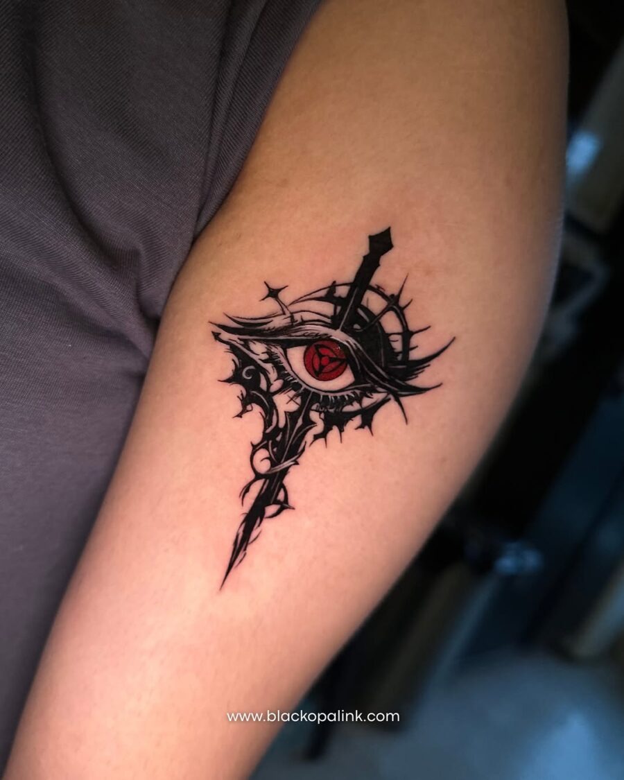 This tattoo features a striking anime eye integrated with a sword, showing bold lines and intricate details.