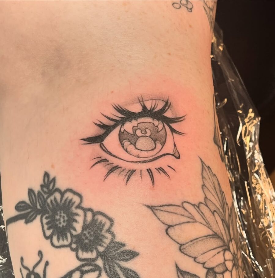 This tattoo features a striking anime eye, elegantly adorned with delicate lashes.
