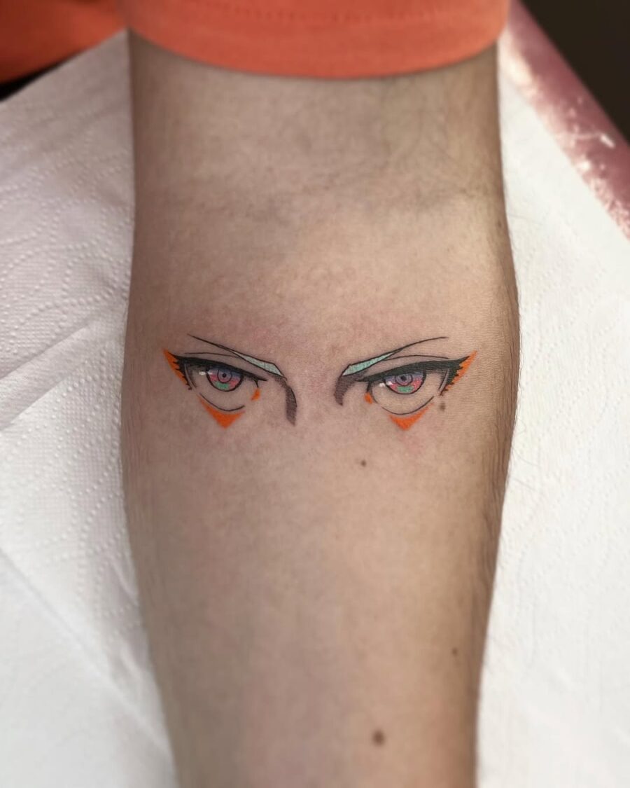 This tattoo features striking anime eyes with pink irises and bold black outlines.