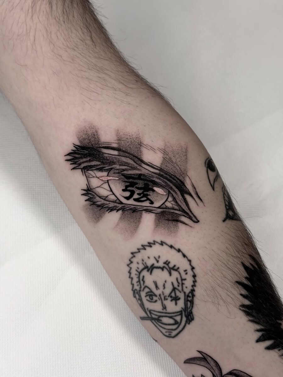 This tattoo features a beautifully detailed anime eye with an intricate design.