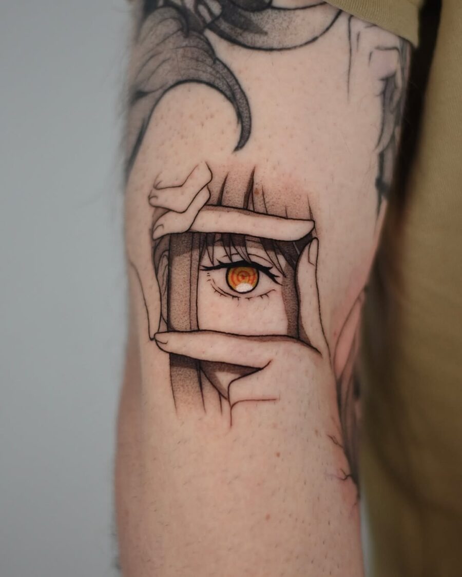 This tattoo features a striking eye framed by hands, creating a captivating optical illusion.