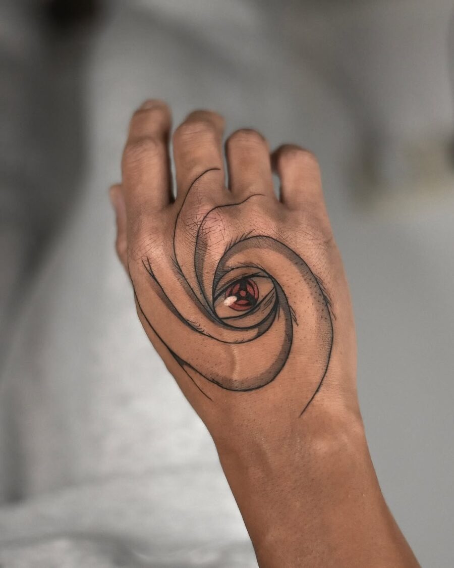 This striking tattoo features a swirling design that draws the viewer's attention to a vivid red eye at its center.