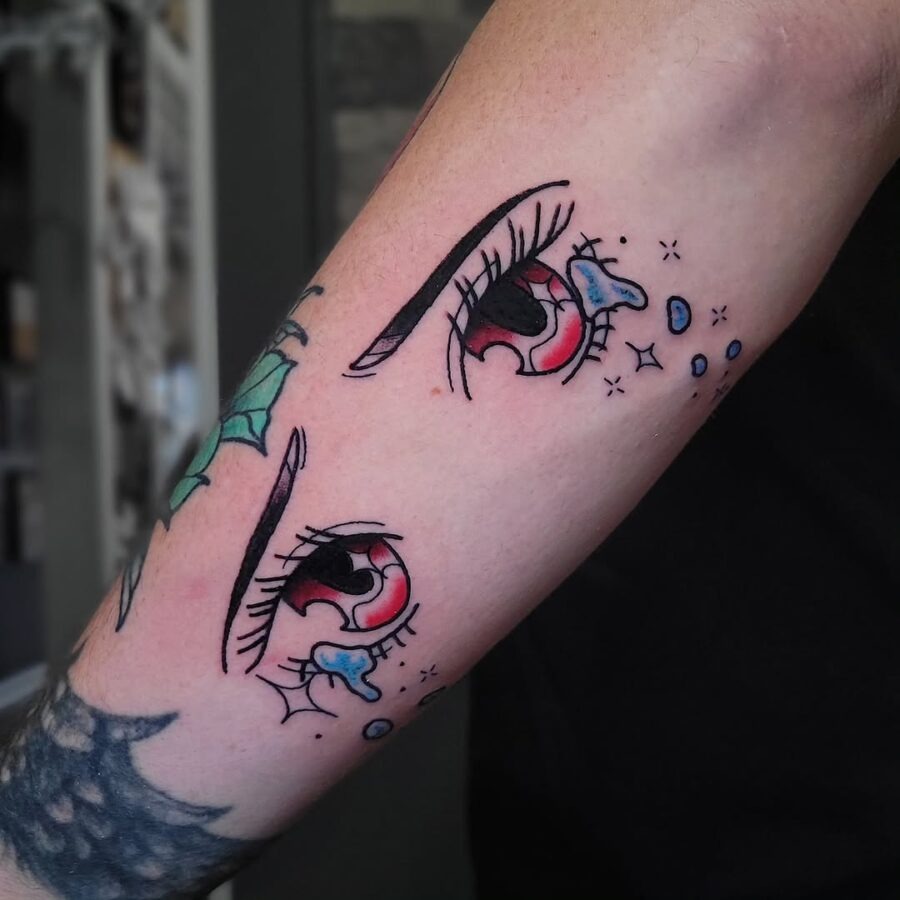 This tattoo showcases striking anime eyes with vivid colors, encapsulating a playful yet mysterious vibe.