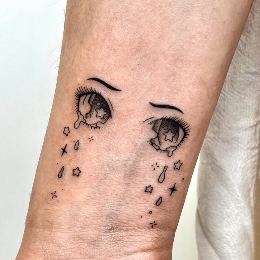 This tattoo features expressive anime eyes, complete with detailed eyelashes and star-filled irises.