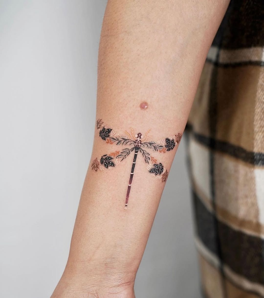 Elegant dragonfly tattoo with floral accents Tattoo Design
